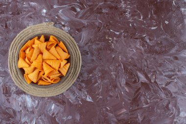 Mermer arka planda, trivet kasesindeki koni cipsleri. Yüksek kalite fotoğraf