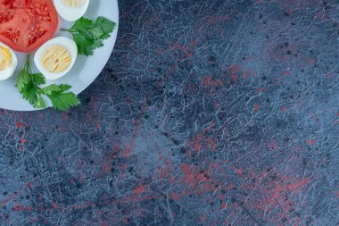 Mavi bir tabak haşlanmış yumurta ve sebze. Yüksek kalite fotoğraf