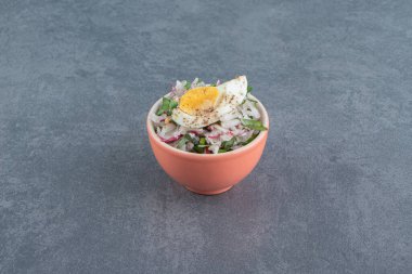 Lezzetli haşlanmış yumurta ve turuncu kasede taze salata. Yüksek kalite fotoğraf