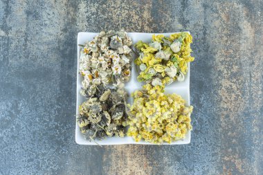 Beyaz tabakta dört çeşit kurutulmuş çiçek. Yüksek kalite fotoğraf