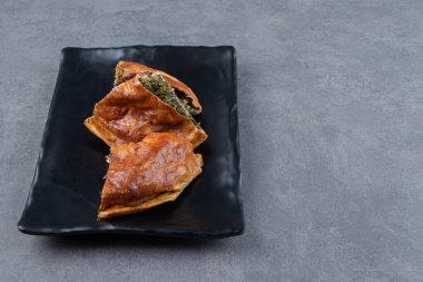 Siyah tabakta yeşillikler olan taze hamur işi. Yüksek kalite fotoğraf