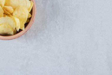 Taş zeminde, kaseye yerleştirilmiş tuzlanmış cips yığını. Yüksek kalite fotoğraf