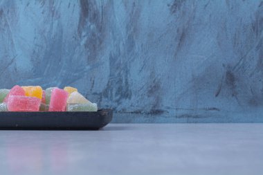 Renkli meyve şekerli marmelatlarla dolu siyah bir tahta. Yüksek kalite fotoğraf