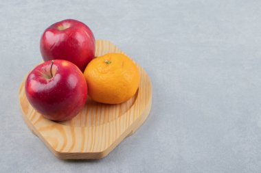 Tahta tabakta kırmızı elma ve mandalina. Yüksek kalite fotoğraf