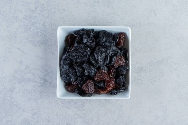 Taş zeminde beyaz bir kase kurutulmuş hurma. Yüksek kalite fotoğraf