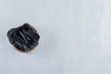 Tahta arka planda çıtır çıtır siyah cips kasesi. Yüksek kalite fotoğraf