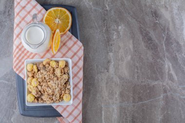 Sağlıklı mısır gevreği ve tahta bir tahtanın üzerinde portakal meyvesi dilimleri olan bir kavanoz süt. Yüksek kalite fotoğraf