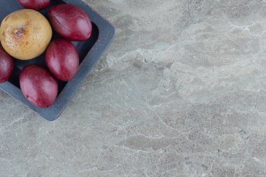 Elma ve avuçların gri ahşap tabakta yakın fotoğrafını çek. Yüksek kalite fotoğraf