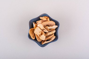 Siyah kase, beyaz masaya yerleştirilmiş elma halkaları. Yüksek kalite fotoğraf