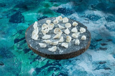 Mavi arka planda pişmemiş Türk mantısı. Yüksek kalite fotoğraf