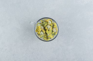 Taş arka planda sarı çiçeklerle dolu cam bardak. Yüksek kalite fotoğraf