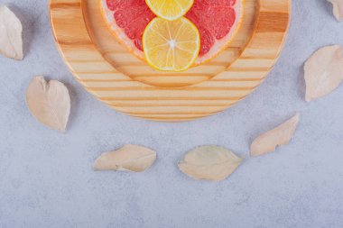 Taze greyfurt ve ahşap tabakta limon dilimleri. Yüksek kalite fotoğraf