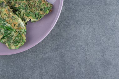 Mor tabakta yeşil sebzeli omlet. Yüksek kalite fotoğraf