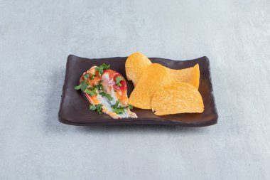 Çıtır cipsler, ketçap ve mayonezle birlikte koyu tabakta. Yüksek kalite fotoğraf