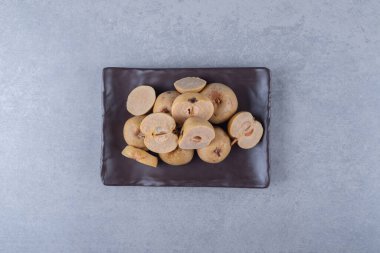 Ahşap bir tabakta, mermer zemin üzerinde tam ve dilimlenmiş elmalar. Yüksek kalite fotoğraf