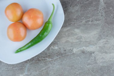 Beyaz tabakta taze domates ve yeşil biber manzarası. Yüksek kalite fotoğraf