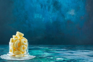 Bardak altlığında, mavi arka planda nefis mısır halkaları. Yüksek kalite fotoğraf