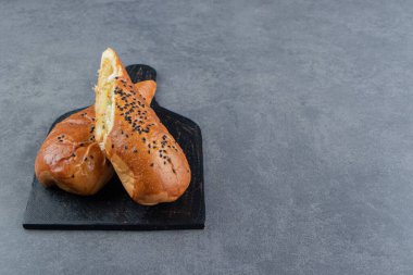 Siyah tahtada susam tohumlu yarı kesilmiş taze hamur işleri. Yüksek kalite fotoğraf