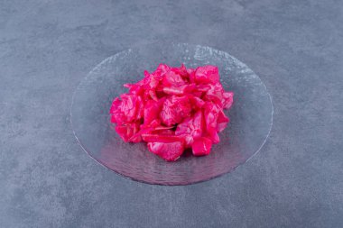 Gri arka planda cam plaka üzerine doğranmış pembe lahanalar. Yüksek kalite fotoğraf