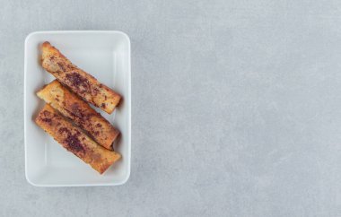 Beyaz kasede kızarmış puro şeklinde hamur işleri. Yüksek kalite fotoğraf