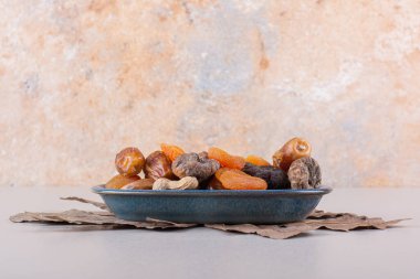 Beyaz arka planda çeşitli organik fındıklı ve meyveli mavi kase. Yüksek kalite fotoğraf