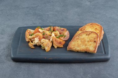 Yağda pişmiş yumurta ve siyah tabakta ekmek dilimleri. Yüksek kalite fotoğraf