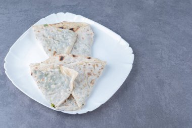 Mermer arka planda, bitkilerle birlikte lezzetli, yassı ekmek kutuları. Yüksek kalite fotoğraf