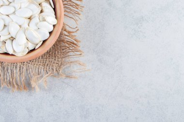 Taş zeminde seramik bir kap çiğ kabak çekirdeği. Yüksek kalite fotoğraf