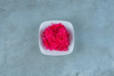 Lezzetli kıyılmış kırmızı mayalanmış lahana turşusu kasede, mavi arka planda. Yüksek kalite fotoğraf