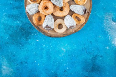 Kurutulmuş elma halkaları ve hurmalar tahtada, mavi arka planda. Yüksek kalite fotoğraf