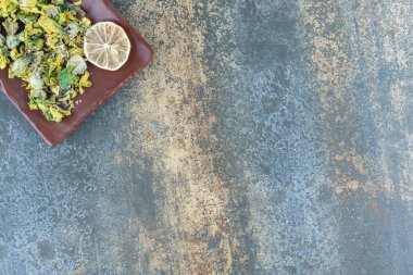 Kahverengi tabakta kurutulmuş kasımpatı ve limon dilimleri. Yüksek kalite fotoğraf