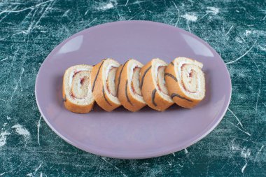 Dilimlenmiş kekler bir tabakta, mavi arkaplanda. Yüksek kalite fotoğraf