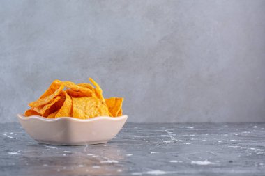 Bir kase lezzetli patates cipsi, mermer arka planda. Yüksek kalite fotoğraf