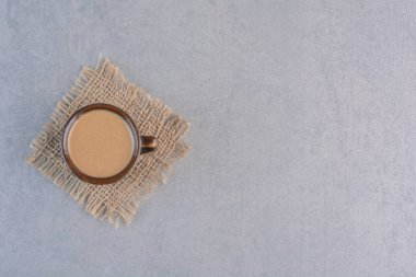 Taş zeminde çuval bezi olan bir fincan lezzetli kahve. Yüksek kalite fotoğraf