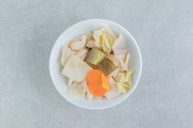 Mermer arka planda, kâsede iştah açıcı sebze turşusu. Yüksek kalite fotoğraf