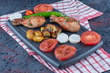 Koyu ahşap bir tahta, sebzeli fırında tavuk eti. Yüksek kalite fotoğraf