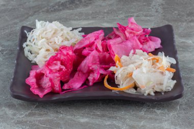 Siyah tabakta lahana turşusu ve pembe lahana resmi. Yüksek kalite fotoğraf