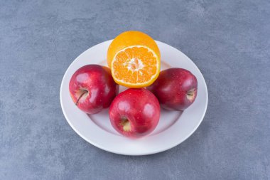 Elma ve portakal tabakta, mermer arka planda. Yüksek kalite fotoğraf