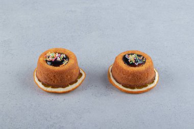 Portakal diliminin üzerine jöleli iki mini kek. Yüksek kalite fotoğraf