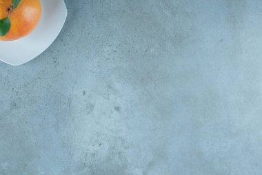 Lezzetli bir portakal tabakta, mermer arka planda. Yüksek kalite fotoğraf