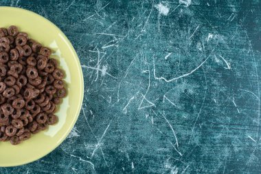 Mavi arka planda bir tabak çikolatalı mısır halkası. Yüksek kalite fotoğraf