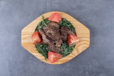 Ahşap tabakta ızgara kebap ve domates dilimleri. Yüksek kalite fotoğraf