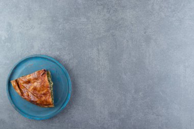 Siyah kesim tahtasına yeşillikle doldurulmuş bir dilim turta. Yüksek kalite fotoğraf