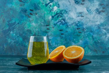 Armut suyu ve dilimlenmiş portakal suyu bir tabakta, mavi arka planda. Yüksek kalite fotoğraf