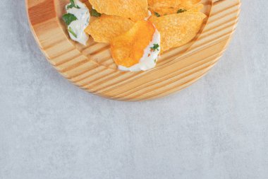 Tuzlu çıtır cips ve ahşap tabakta taze yoğurt. Yüksek kalite fotoğraf