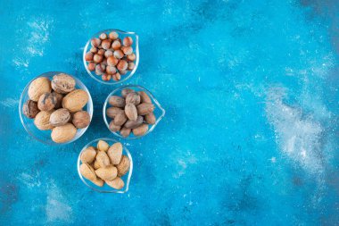 Mavi arka planda, kaselerin üzerinde fındık çeşitleri. Yüksek kalite fotoğraf