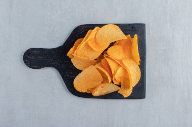 Siyah kesim tahtasında lezzetli patates cipsi. Yüksek kalite fotoğraf