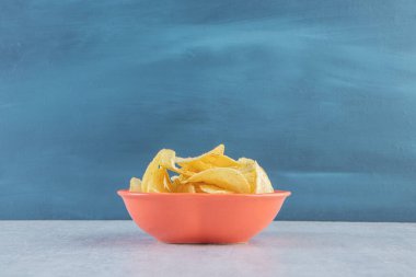 Turuncu kase, arka planda kıtır kıtır tuzlu cips. Yüksek kalite fotoğraf