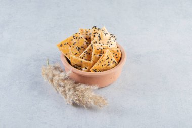 Bir kase kraker ve mermer kaplamalı siyah tohumlar. Yüksek kalite fotoğraf