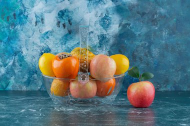 Mermer arka planda, kasede çeşitli meyveler var. Yüksek kalite fotoğraf